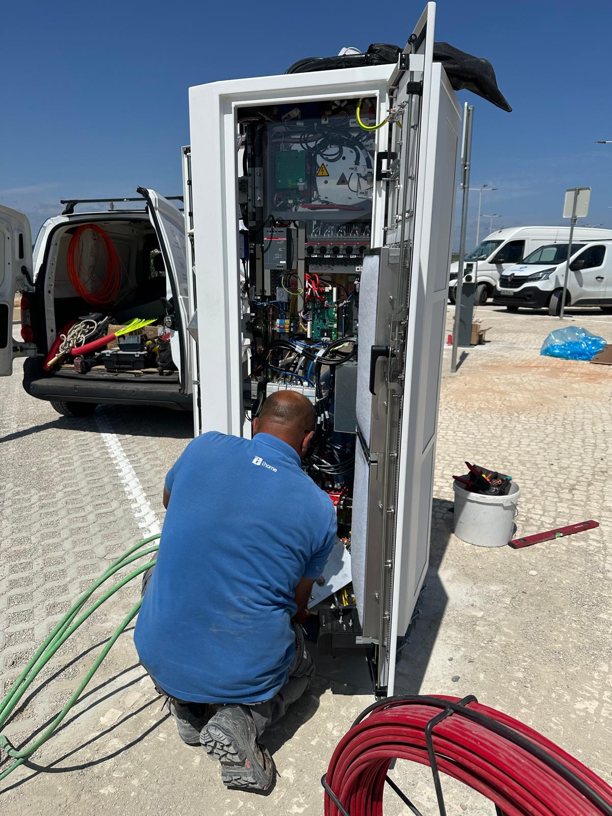 Técnico com vestuário iHome a trabalhar no interior do carregador aberto.